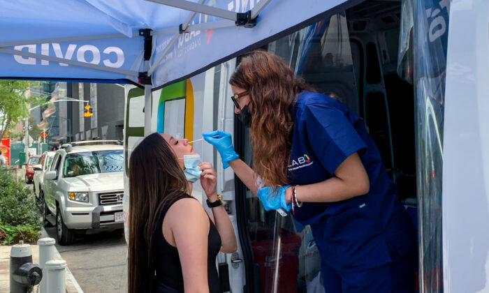 A medical worker takes a nasal swab sample from a woman at COVID-19 testing booth in New York on Sept. 20, 2021. (Chung I Ho/The Epoch Times)