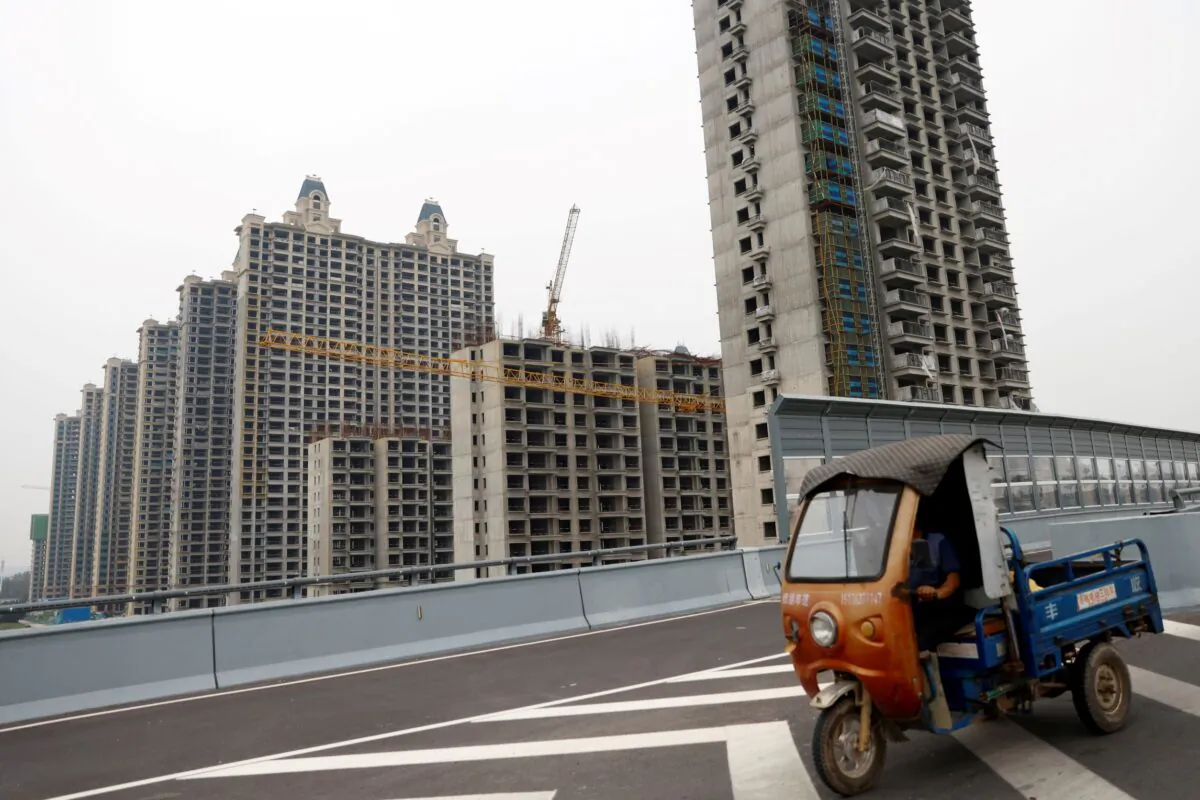 A vehicle drives past unfinished residential buildings at Evergrande Oasis, a housing complex developed by Evergrande Group, in Luoyang, China, on Sept. 16, 2021. (Carlos Garcia Rawlins/Reuters)