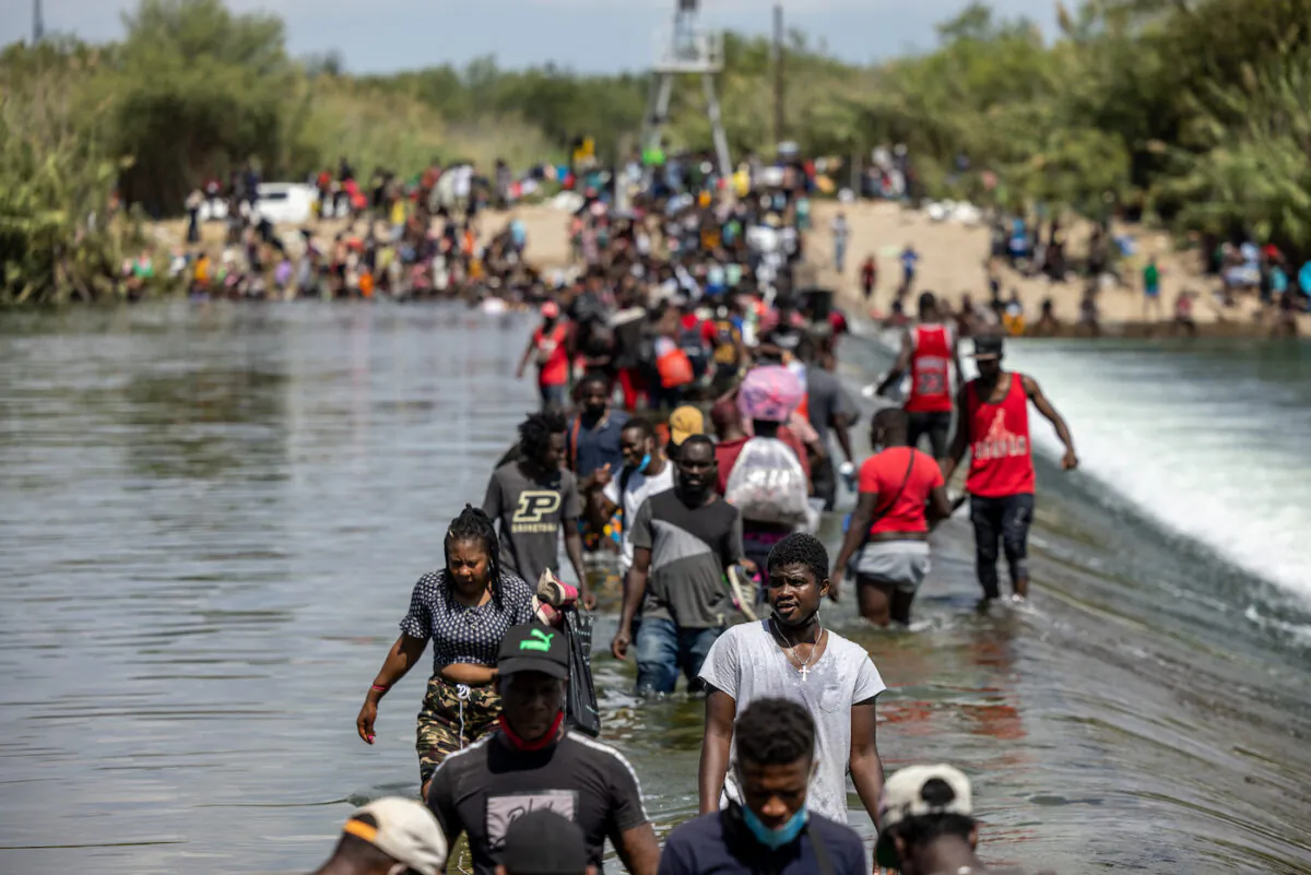 Illegal migrants cross the Rio Grande River near a temporary migrant camp under the international bridge on Sept. 18, 2021, in Del Rio, Texas. (Jordan Vonderhaar/Getty Images)