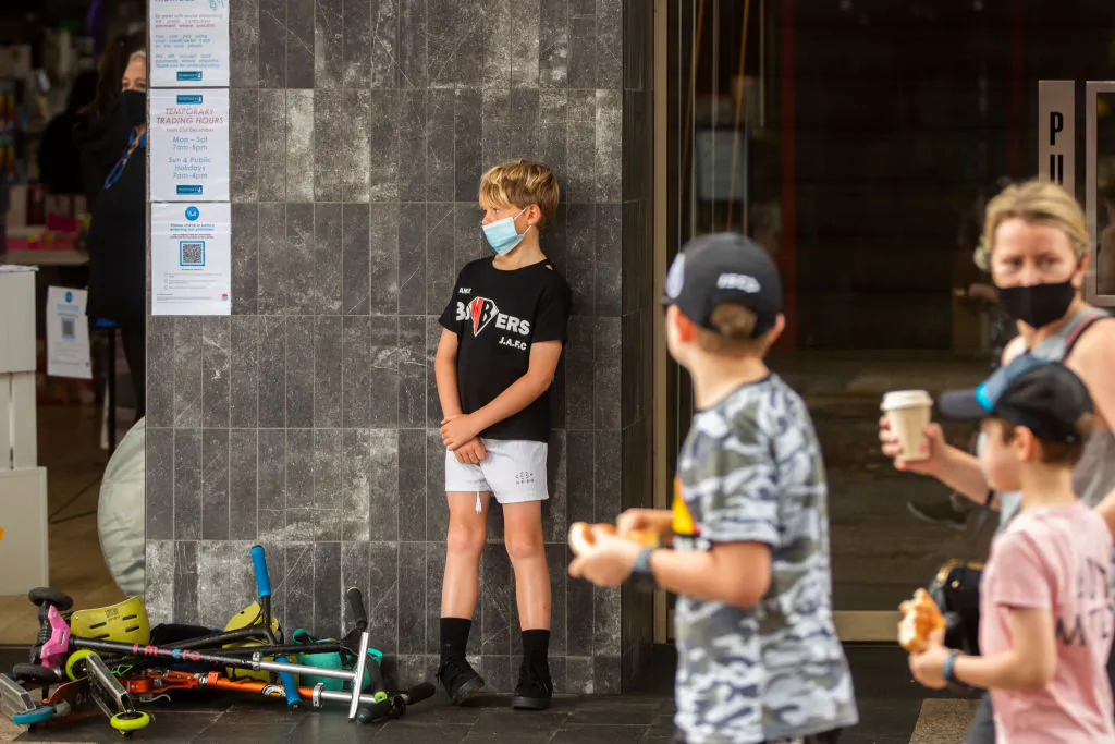 A boy wearing a mask stands at the front of a store in Manly, Sydney, Australia, on January 3, 2021. (Jenny Evans/Getty Images)