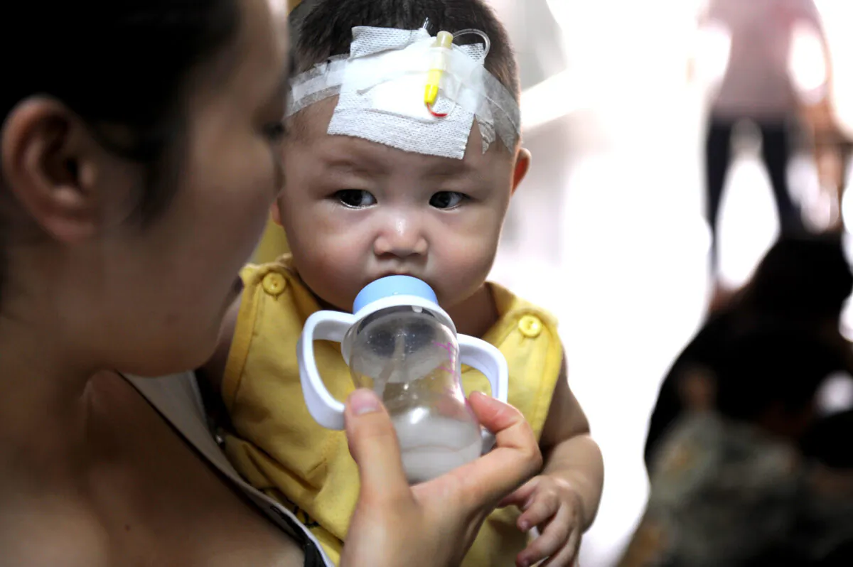A woman feeds a baby who suffers from kidney stones after drinking tainted milk powder at the Chengdu Children's Hospital on September 22, 2008 in Chengdu of Sichuan Province, China.
(China Photos/Getty Images)