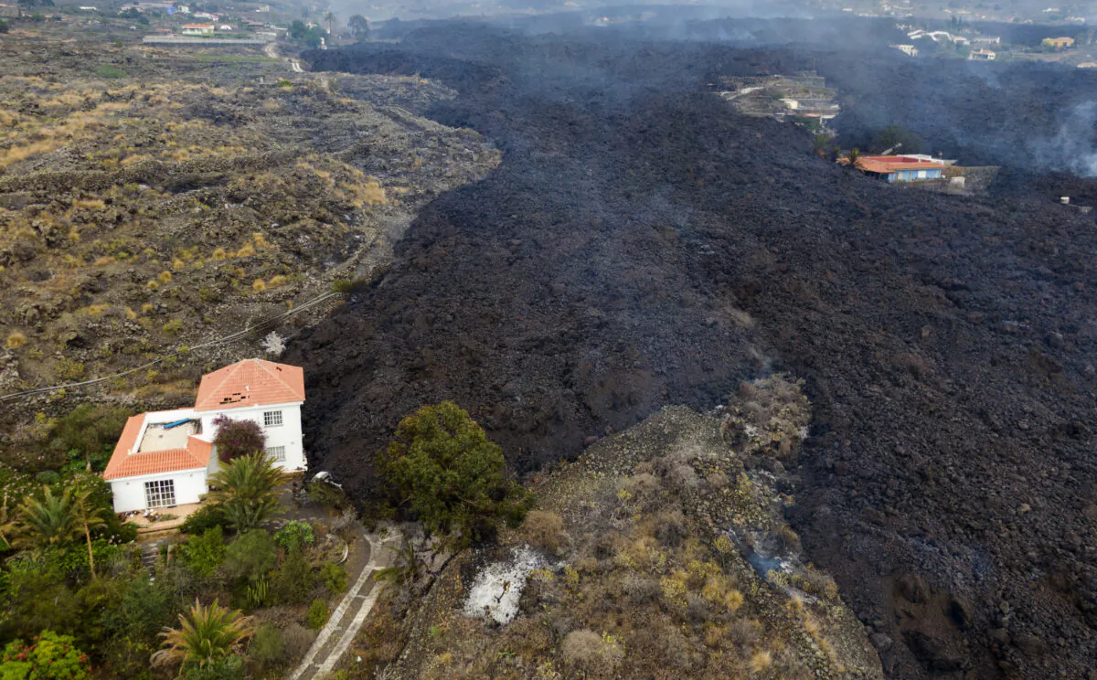Lava from a volcano eruption flows destroying houses on the island of La Palma in the Canaries, Spain, on Sept. 21, 2021.  (Emilio Morenatti/AP Photo)