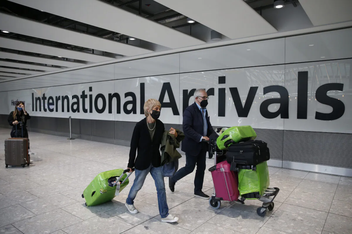 Travellers exit through the International Arrivals gate at Heathrow Airport in London, England, on Aug. 7, 2021. (Hollie Adams/Getty Images)