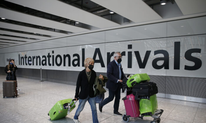 Travellers exit through the International Arrivals gate at Heathrow Airport in London, England, on Aug. 7, 2021. (Hollie Adams/Getty Images)