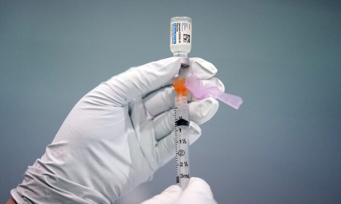A member of the Philadelphia Fire Department prepares a dose of the Johnson & Johnson COVID-19 vaccine at a vaccination site setup in Philadelphia on March 26, 2021. (Matt Rourke/AP Photo)
