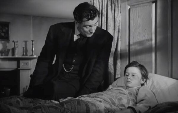 man talking to boy in sick bed