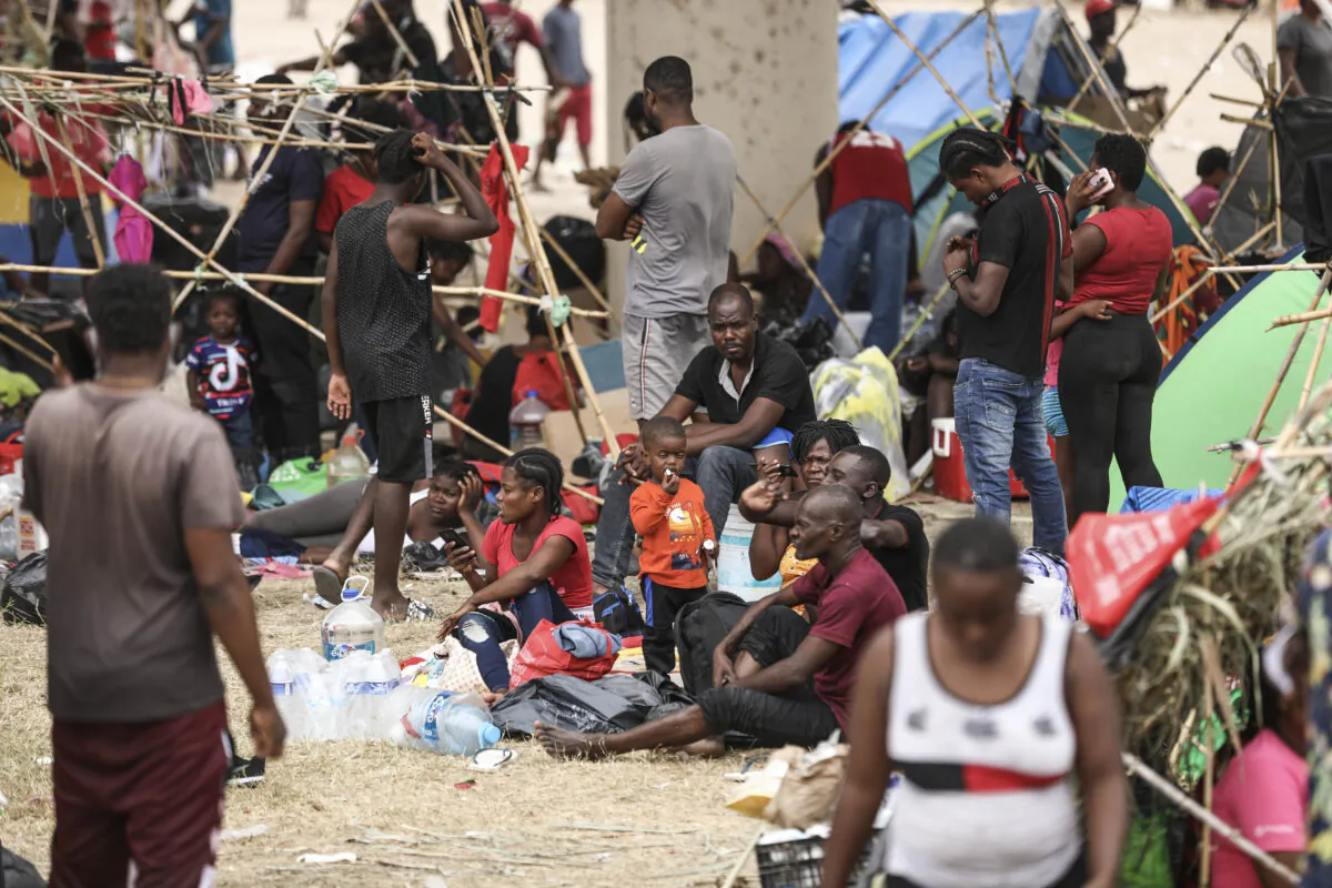 Thousands of illegal immigrants, mostly Haitians, live in a primitive, makeshift camp under the International Bridge, that spans the Rio Grande between the United States and Mexico, while waiting to be detained and processed by Border Patrol, in Del Rio, Texas, on Sept. 21, 2021. (Charlotte Cuthbertson/The Epoch Times)