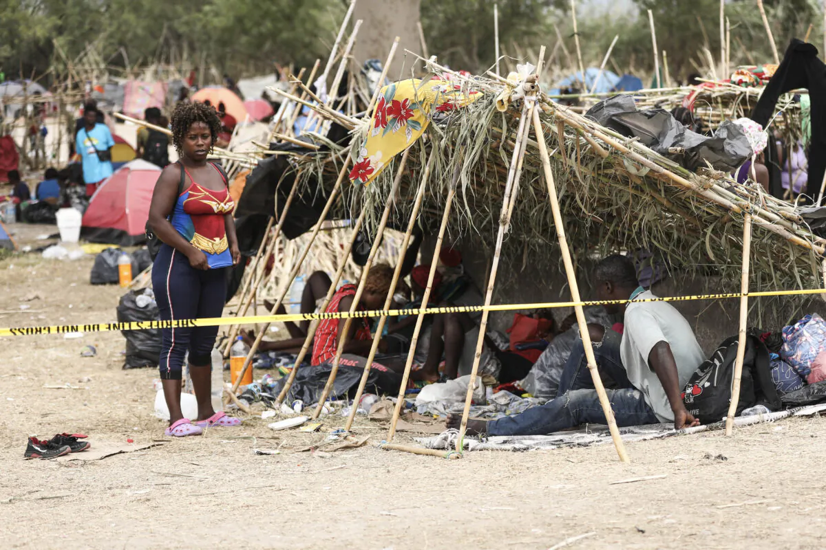 Thousands of illegal immigrants, mostly Haitians, live in a primitive, makeshift camp under the international bridge that spans the Rio Grande between the United States and Mexico while waiting to be detained and processed by Border Patrol, in Del Rio, Texas, on Sept. 21, 2021. (Charlotte Cuthbertson/The Epoch Times)