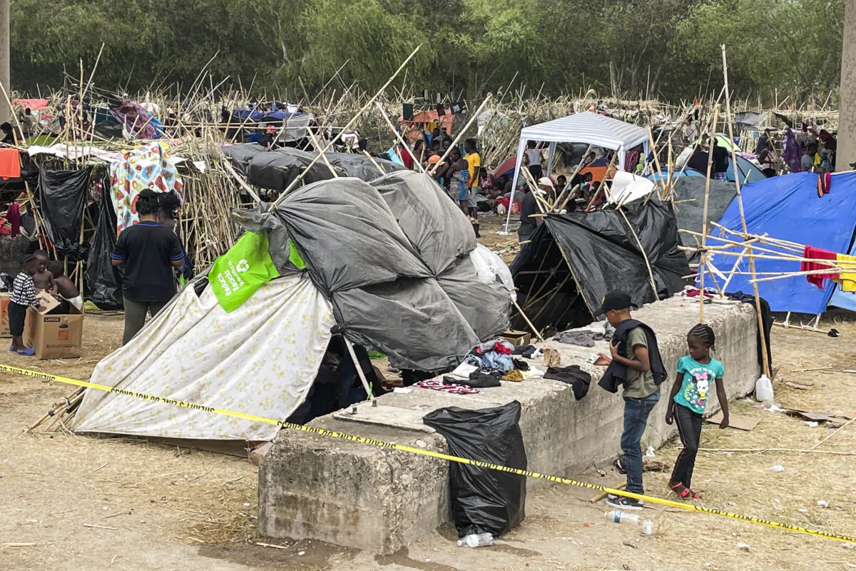 Thousands of illegal immigrants, mostly Haitians, live in a primitive, makeshift camp under the international bridge that spans the Rio Grande between the U.S. and Mexico while waiting to be detained and processed by Border Patrol, in Del Rio, Texas, on Sept. 21, 2021. (Charlotte Cuthbertson/The Epoch Times)