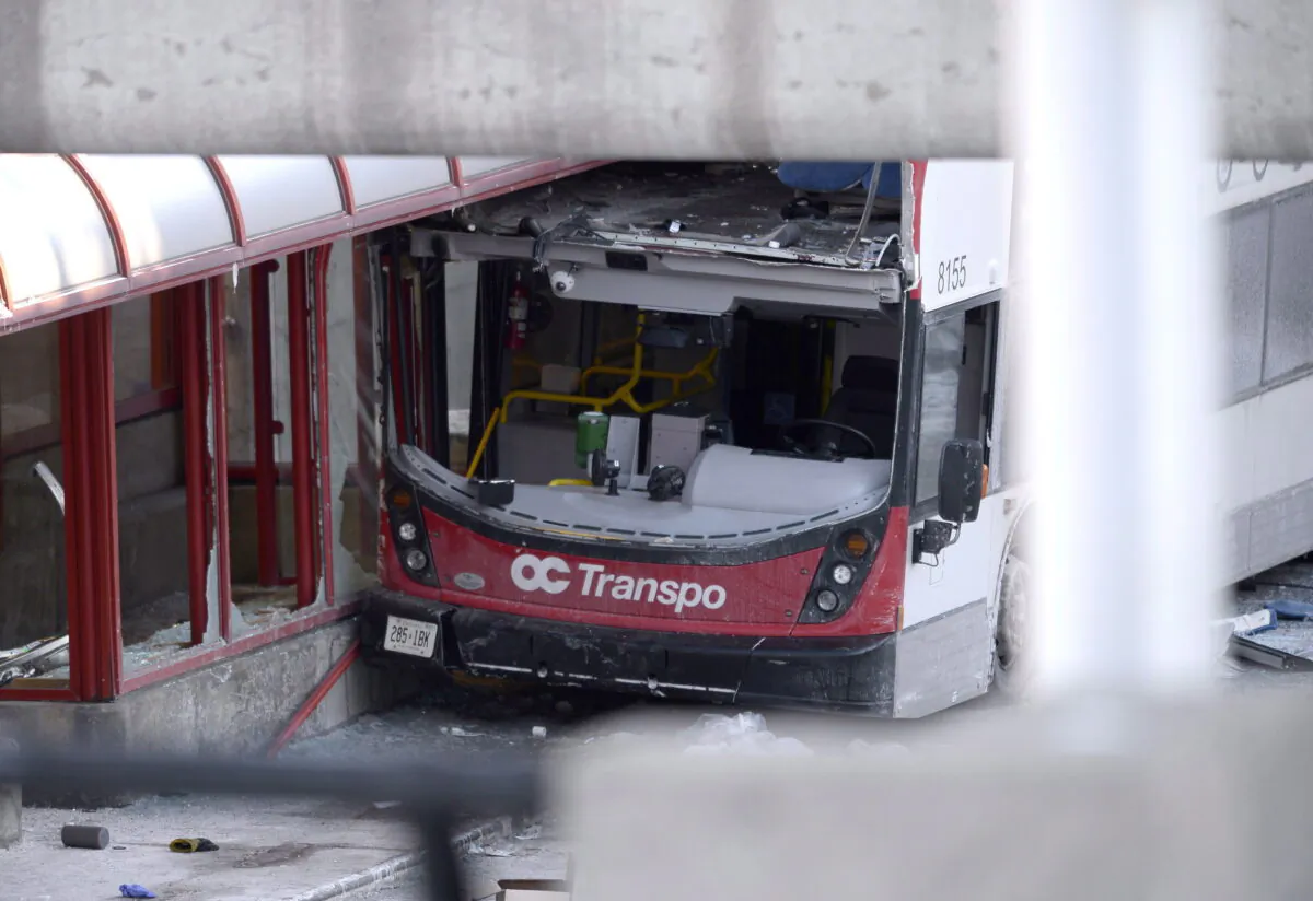 A double-decker city bus that struck a transit shelter at the start of the afternoon rush hour on Friday, remains in place at Westboro Station in Ottawa, on Saturday, Jan. 12, 2019. (The Canadian Press/Justin Tang)