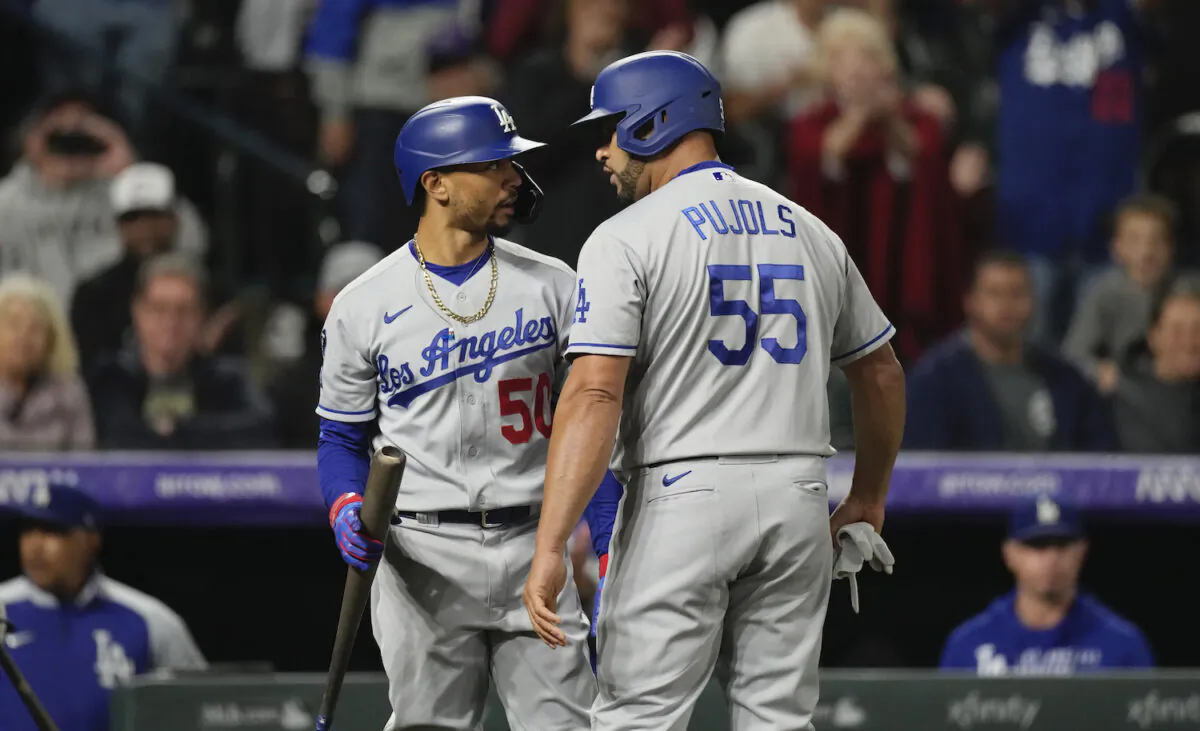 Los Angeles Dodgers’ Mookie Betts, left, congratulates pinch-hitter Albert Pujols as he returns to the dugout after hitting an RBI-single off Colorado Rockies relief pitcher Jhoulys Chacin in the 10th inning of a baseball game in Denver on Sept. 21, 2021. (AP Photo/David Zalubowski)