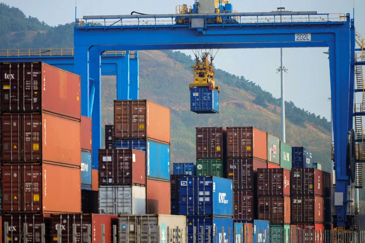 A file photo of a crane loading and lifting containers at an automated cargo wharf in Qingdao in China's eastern Shandong Province. (STR/AFP via Getty Images)