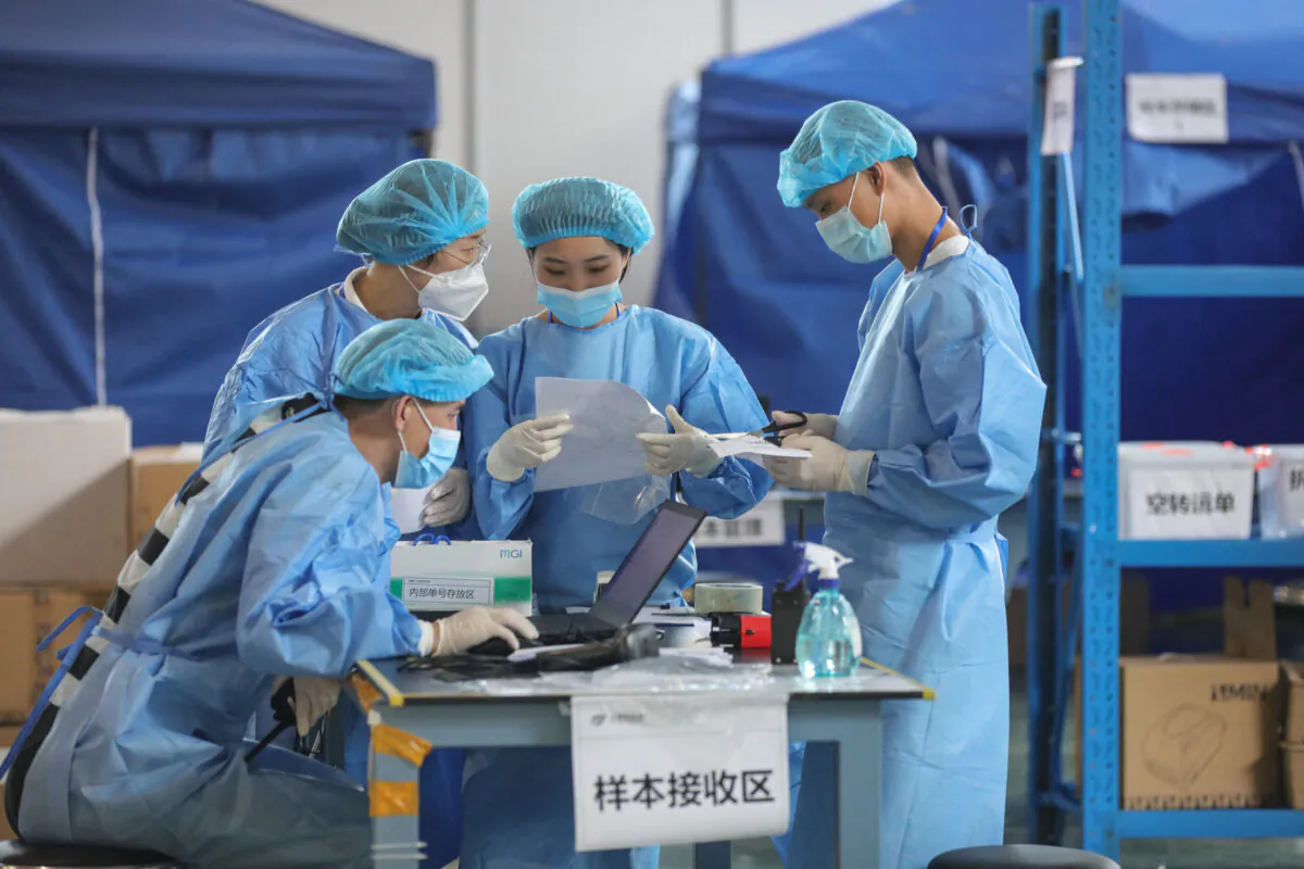 Laboratory technicians wearing personal protective equipment while working in China. (STR/AFP via Getty Images)