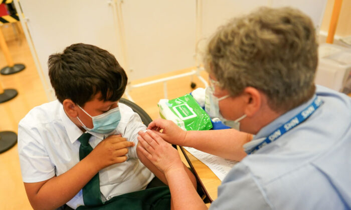 13-year-old boy from Newcastle receives the Pfizer-BioNTech COVID-19 vaccine at the Excelsior Academy in Newcastle upon Tyne, England, on Sept. 22, 2021. (Ian Forsyth/Getty Images)