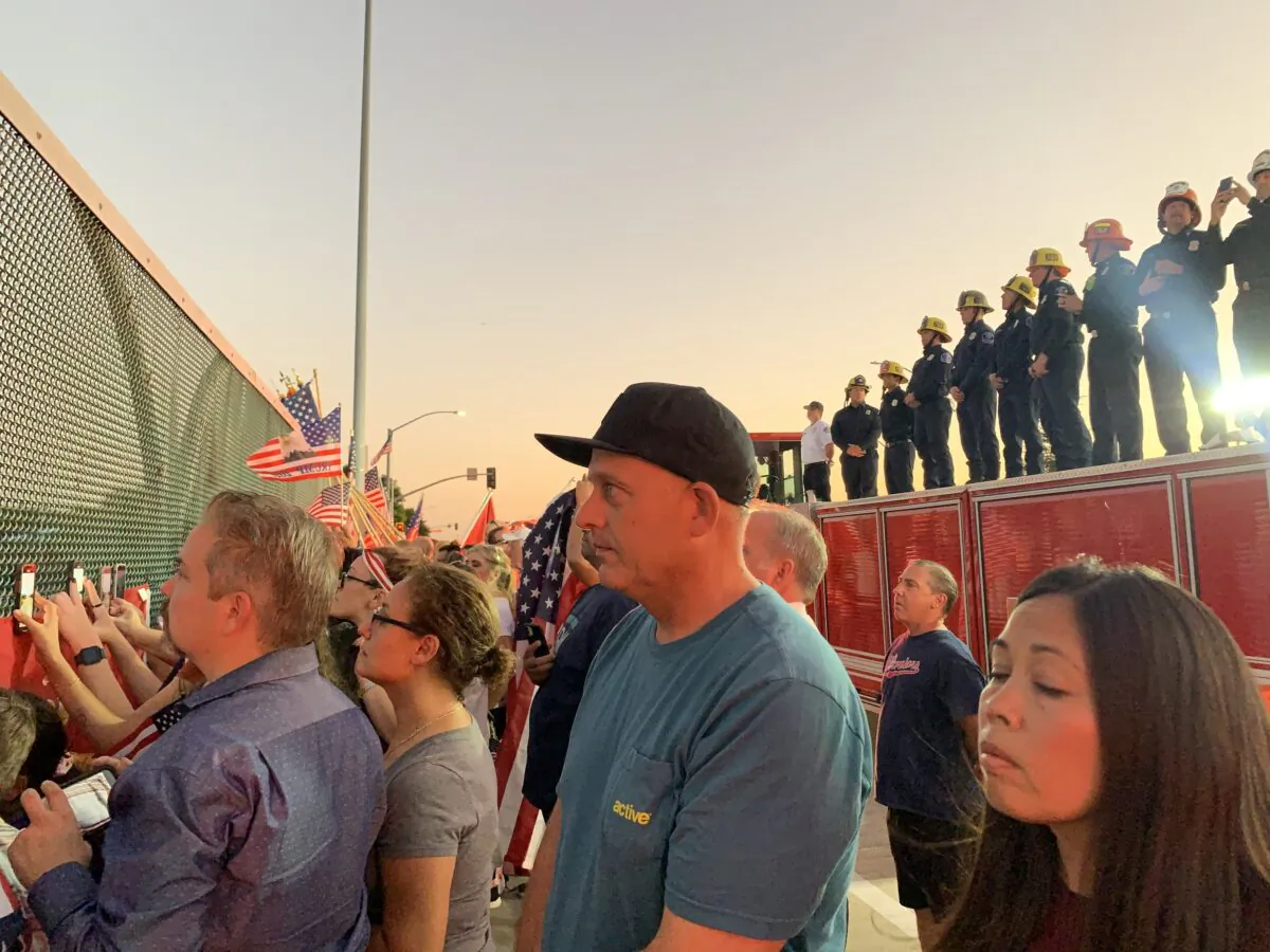 Crowds of people and La Verne firefighters on the overpass paying tribute to Marine Lance Cpl. Dylan R. Merola, 20, of Rancho Cucamonga, in La Verne, Calif., on Sept. 21, 2021. (Linda Jiang/The Epoch Times)