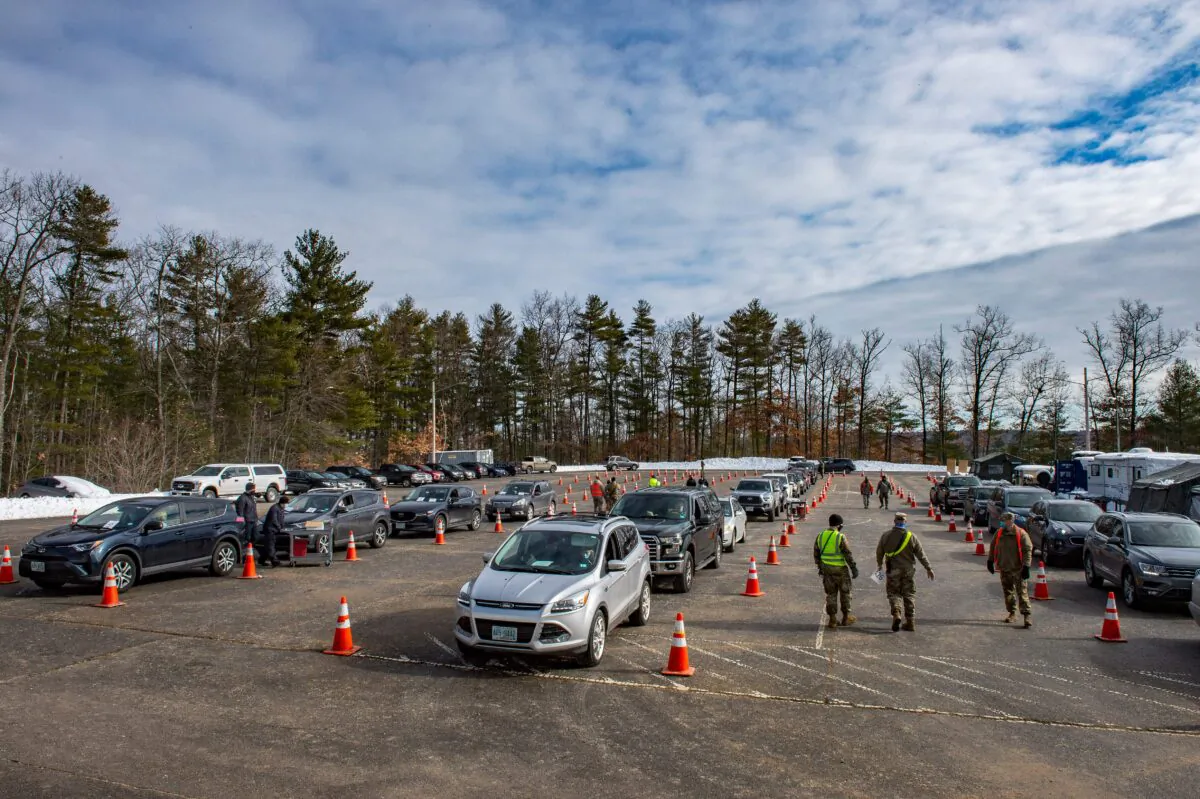 Servicemen coordinate people in their cars as they line up to be vaccinated at a vaccination center in Londonderry, N.H., on Feb. 4, 2021. (Joseph Prezioso/AFP via Getty Images)