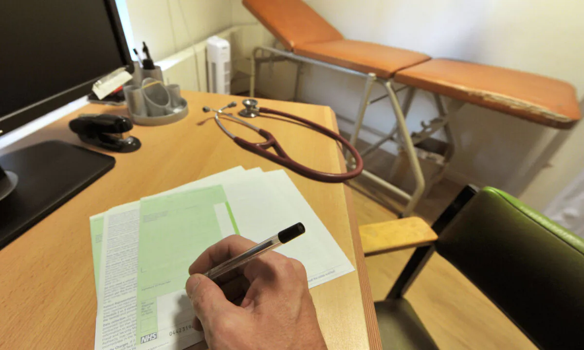 File photo showing a doctor writing a prescription. (PA)