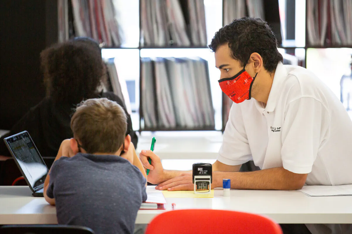 Instructor Arthur Weimholt helps a student perform a math assignment at Mathnasium, in Laguna Niguel, Calif., on May 12, 2021. (John Fredricks/The Epoch Times)