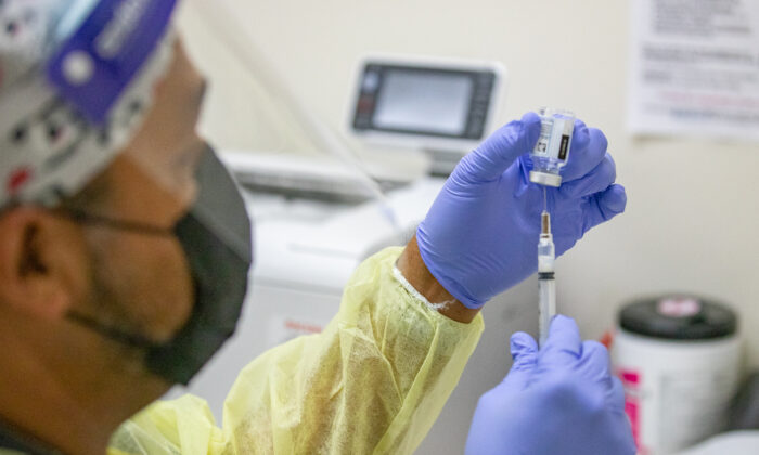 A medical volunteer prepares the Moderna coronavirus vaccination for a patient at Lestonnac Free Clinic in Orange, Calif., on March 9, 2021. (John Fredricks/  Pezou)