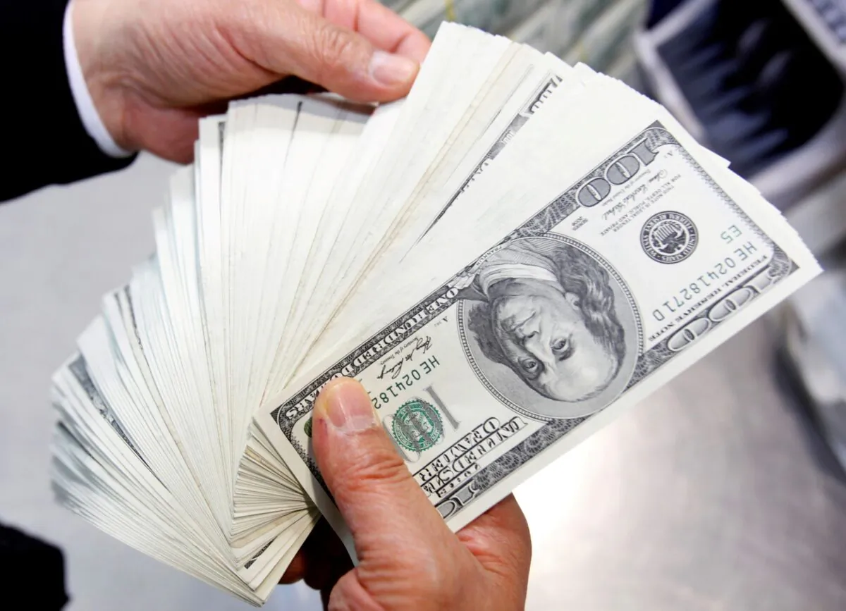 An employee of the Korea Exchange Bank counts one hundred U.S. dollar notes during a photo opportunity at the bank's headquarters in Seoul on April 28, 2010. (Jo Yong-Hak/Reuters)