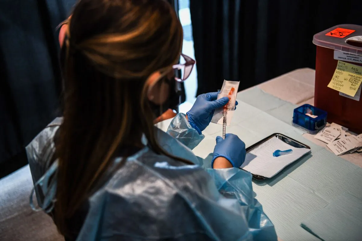 A health care worker prepares a COVID-19 vaccine in Florida in a file photograph. (Chandan Khanna/AFP via Getty Images)