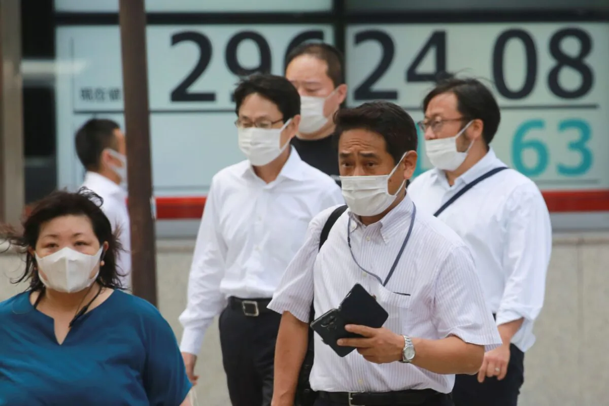 People walk by an electronic stock board of a securities firm in Tokyo, Japan on Sept. 22, 2021.(Koji Sasahara/AP Photo)