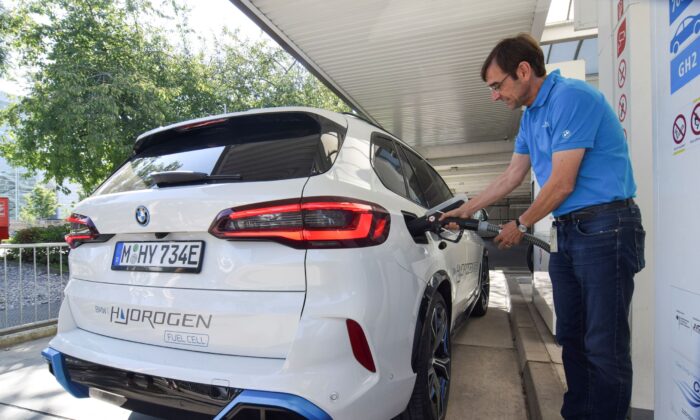 Juergen Guldner, a vice president at BMW in charge of the carmaker's hydrogen car program, fuels a hydrogen fuel-cell prototype SUV at a petrol station in Munich, Germany on  Sept. 3, 2021. (Nick Carey/Reuters)