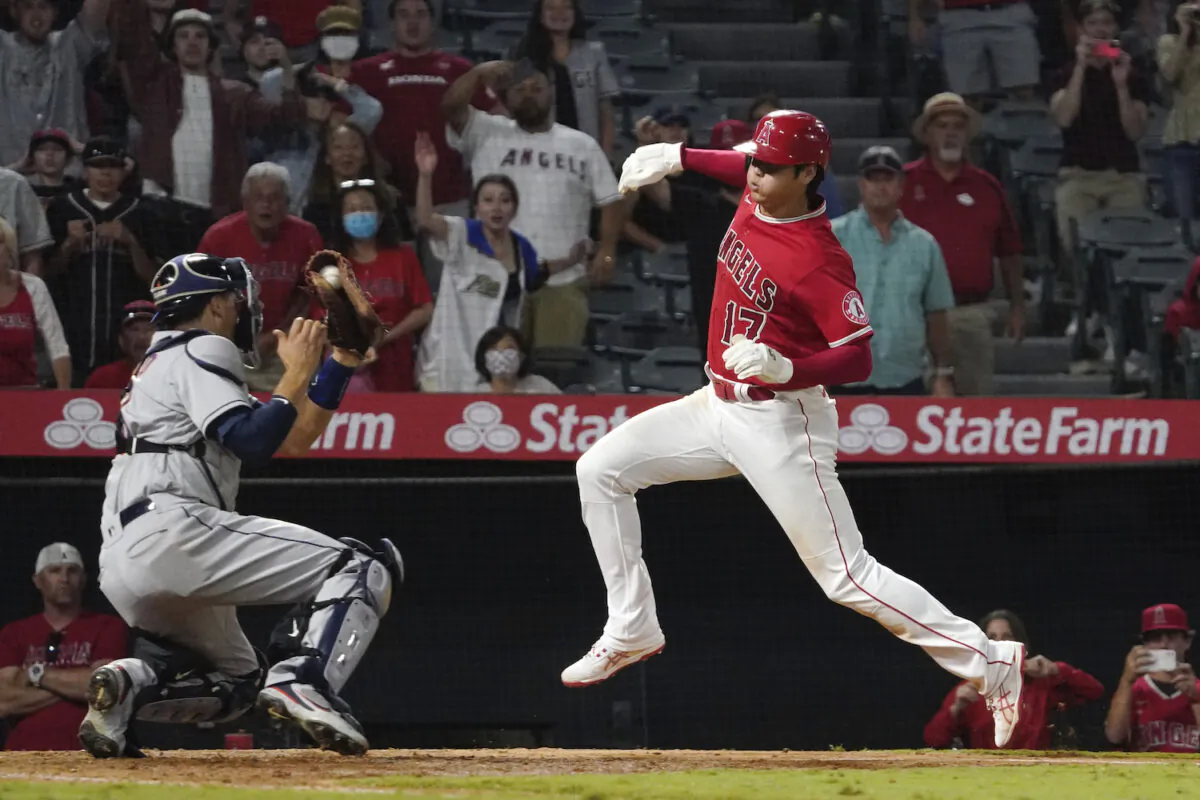 Los Angeles Angels designated hitter Shohei Ohtani, right, avoids a tag by Houston Astros catcher Jason Castro but misses the plate during the 10th inning of a baseball game in Anaheim, Calif., on Sept. 22, 2021. Ohtani was later tagged out by Castro. (AP Photo/Mark J. Terrill)