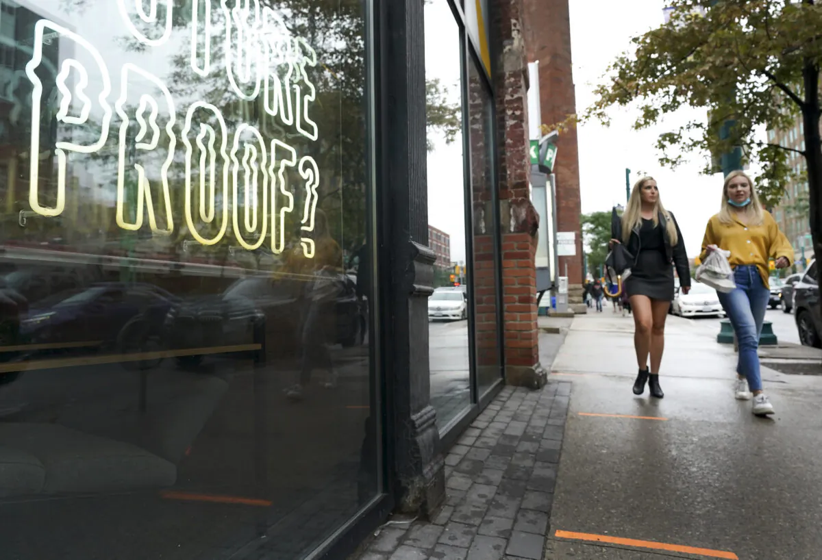 People walk past retail storefronts during the COVID-19 pandemic in Toronto on Sept. 22, 2021. Ontario now requires proof of vaccination to enter many business across the province. (The Canadian Press/Nathan Denette)