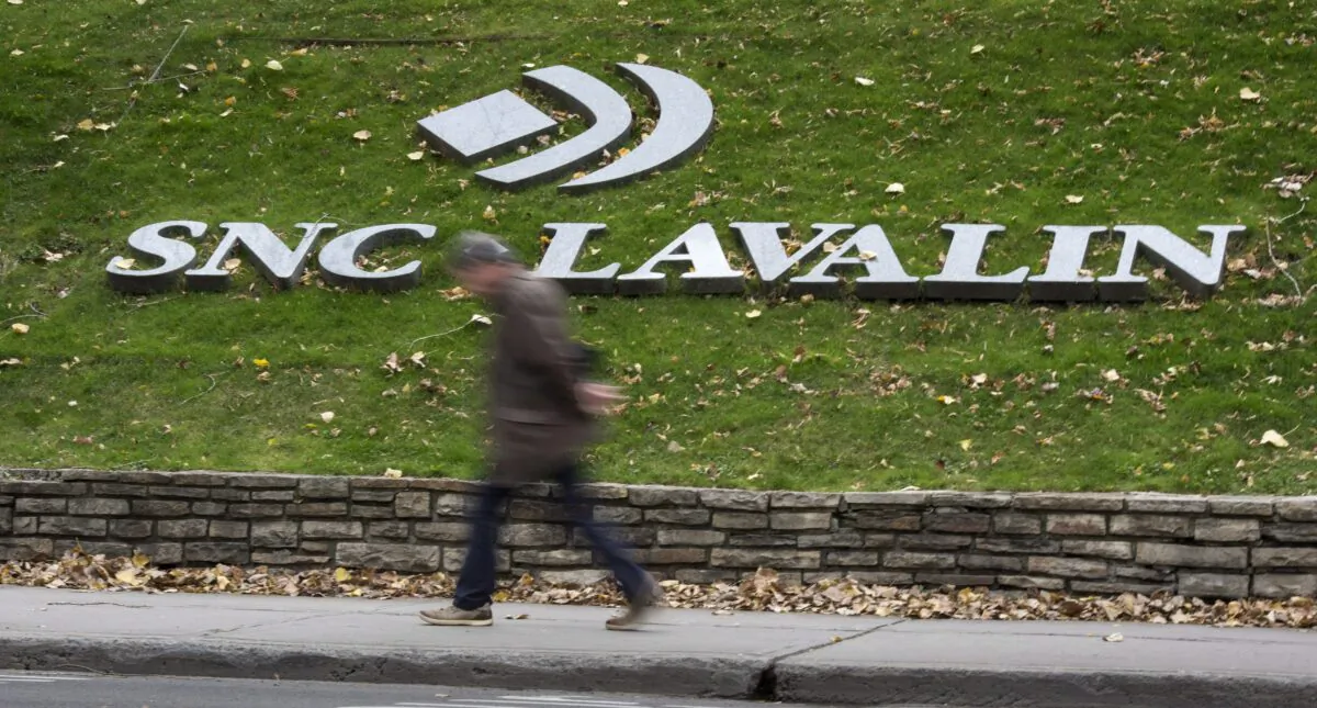 A man walks past the headquarters of SNC Lavalin in Montreal on Nov. 6, 2014. (The Canadian Press/Paul Chiasson)