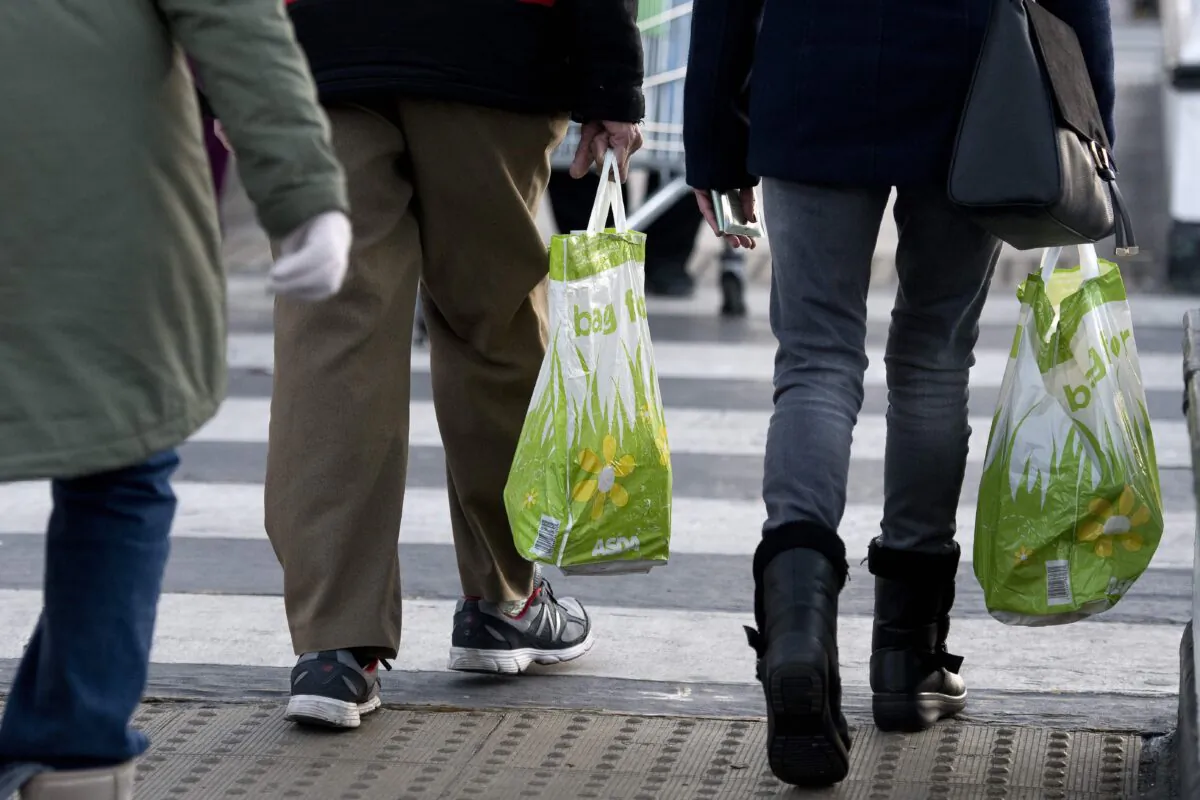 People carry goods in reusable plastic bags after shopping, in this file photo. (Justin Tallis/Getty Images)