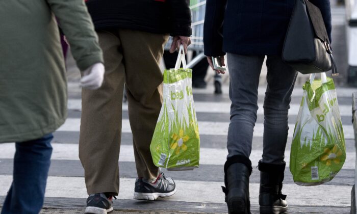 People carry goods in reusable plastic bags after shopping, in this file photo. (Justin Tallis/Getty Images)