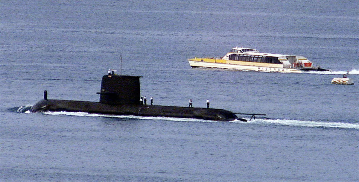 A Rivercat ferry passes by the Royal Australian Navy's Collins-class submarine HMAS Waller as it leaves Sydney Harbour, Australia, on May 4, 2020. (Reuters)