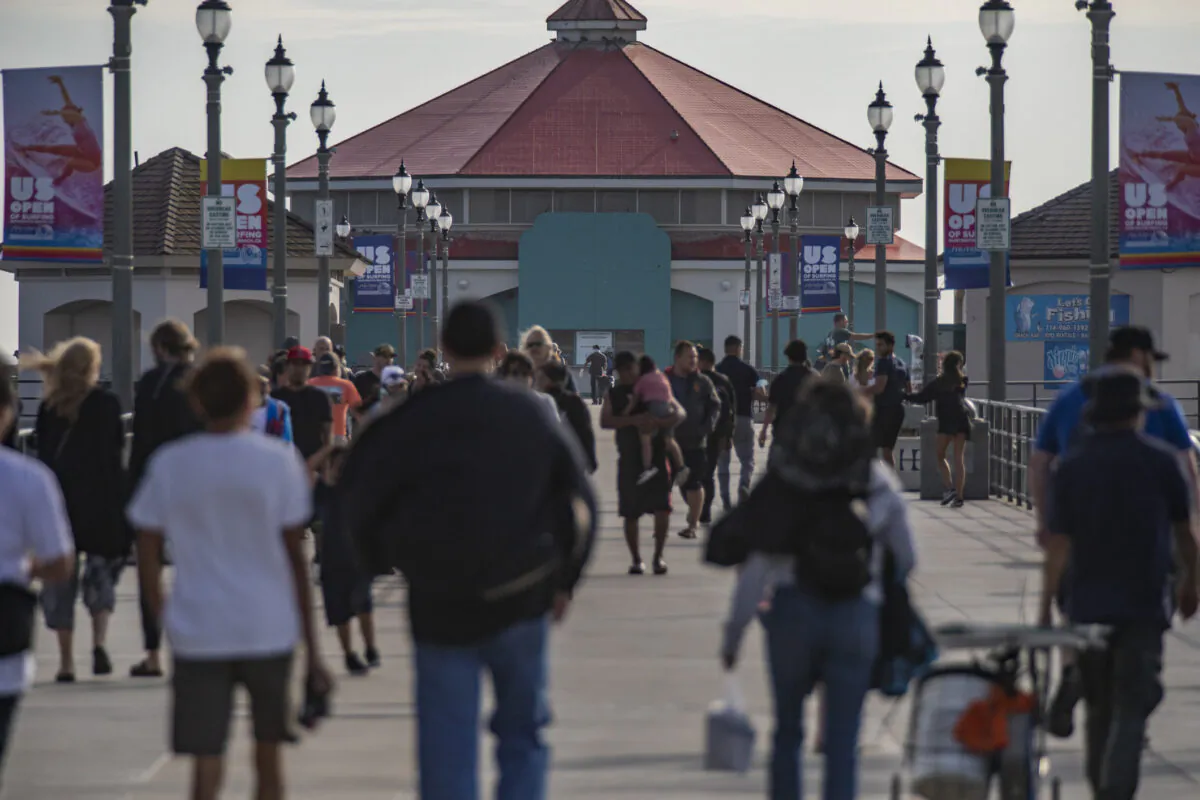 People gather to watch surfers practice for the US Open of Surfing in Huntington Beach, Calif., on Sept. 22, 2021. (John Fredricks/The Epoch Times)