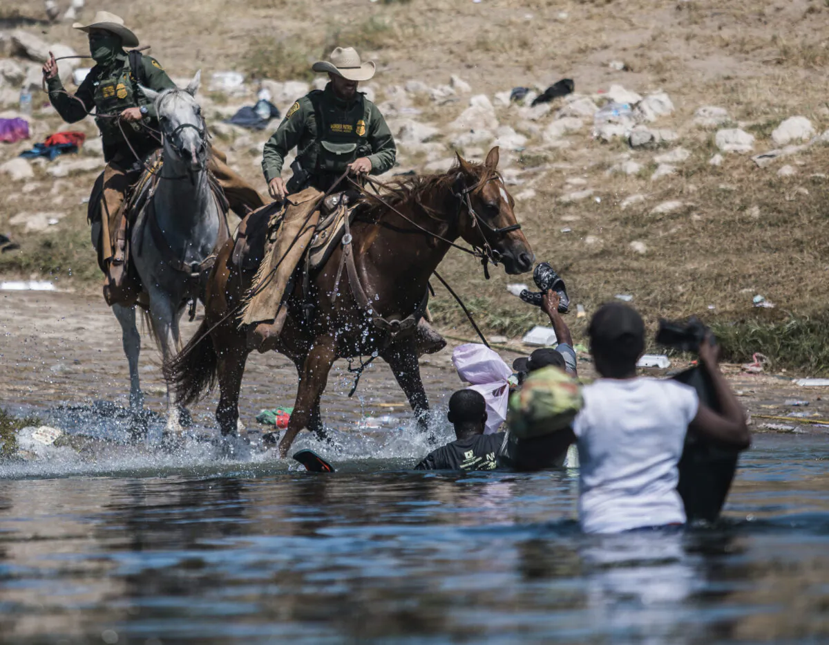 U.S. Border Patrol mounted agents attempt to contain illegal immigrants as they cross the Rio Grande from Ciudad Acuña, Mexico, into Del Rio, Texas, on Sept. 19, 2021. (AP Photo/Felix Marquez)