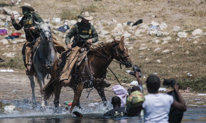 U.S. Border Patrol mounted agents attempt to contain illegal immigrants as they cross the Rio Grande from Ciudad Acuña, Mexico, into Del Rio, Texas, on Sept. 19, 2021. (AP Photo/Felix Marquez)