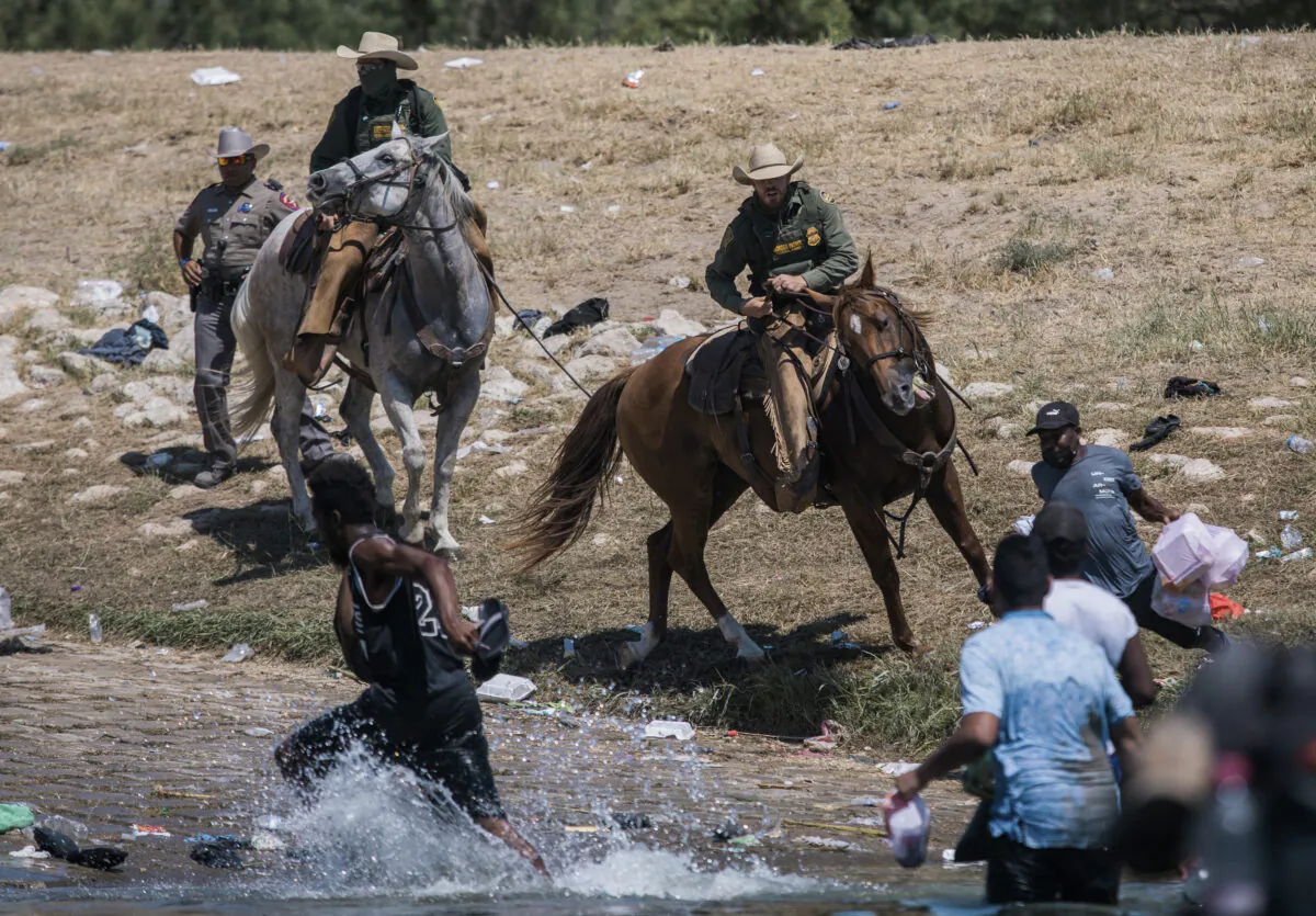U.S. Customs and Border Protection mounted officers attempt to contain migrants as they cross the Rio Grande from Ciudad Acuña, Mexico, into Del Rio, Texas, on Sept. 19, 2021. (Felix Marquez/AP Photo)