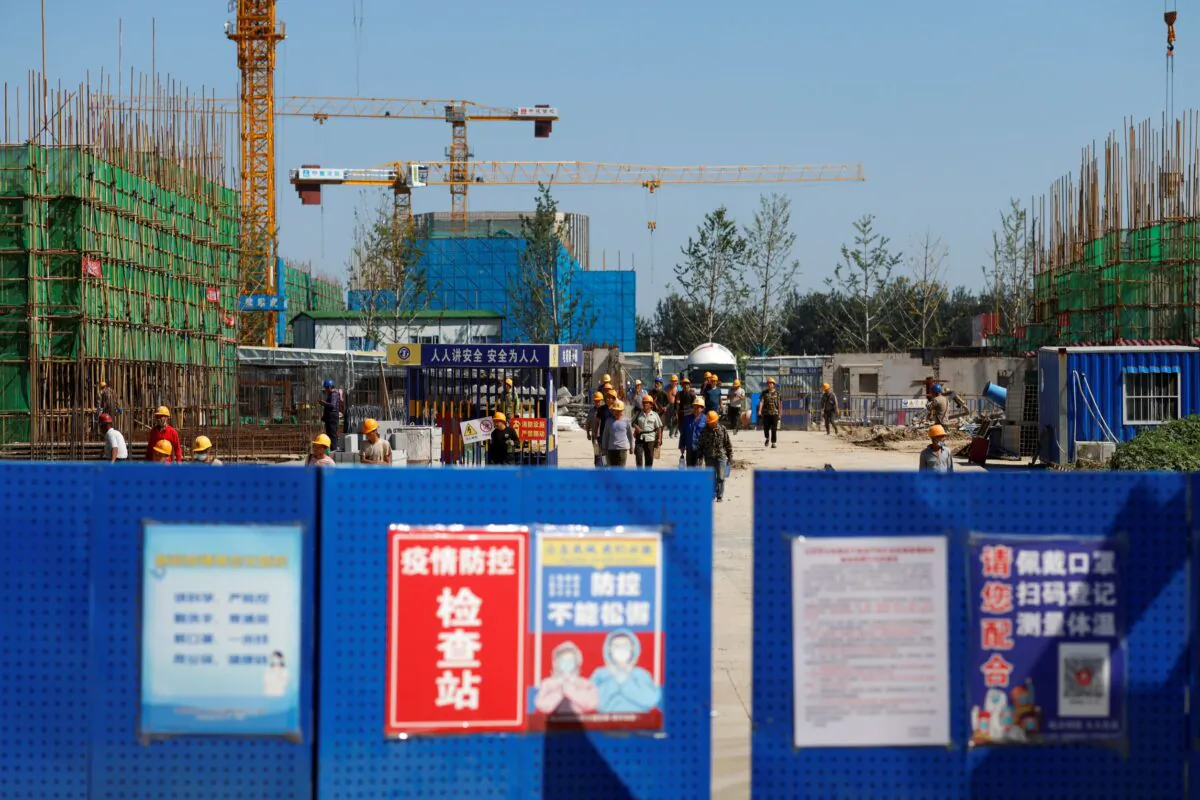 Workers walk inside the construction site of a project developed by China Evergrande Group in Beijing, China on Sept. 22, 2021. (Carlos Garcia Rawlins/Reuters)