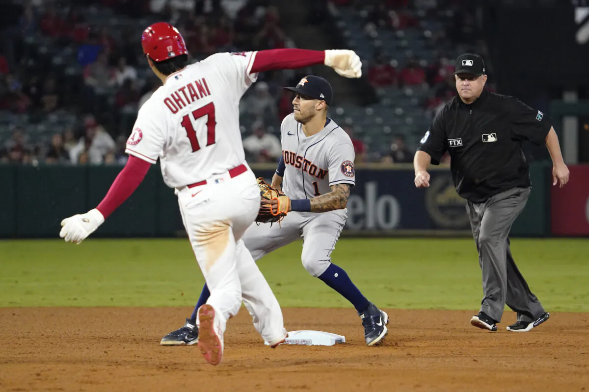 Los Angeles Angels designated hitter Shohei Ohtani, left, steals second as Houston Astros shortstop Carlos Correa, center, waits for the throw while second base umpire Todd Tichenor watches during the sixth inning of a baseball game in Anaheim, Calif., on Sept. 23, 2021. (AP Photo/Mark J. Terrill)