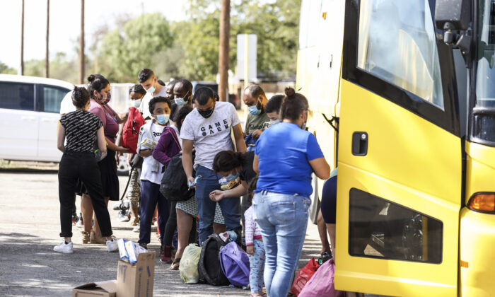 Haitians and others who crossed the U.S. border illegally are seen boarding a bus after being released by federal authorities, in Del Rio, Texas, on Sept. 22, 2021. (Charlotte Cuthbertson/The Epoch Times)