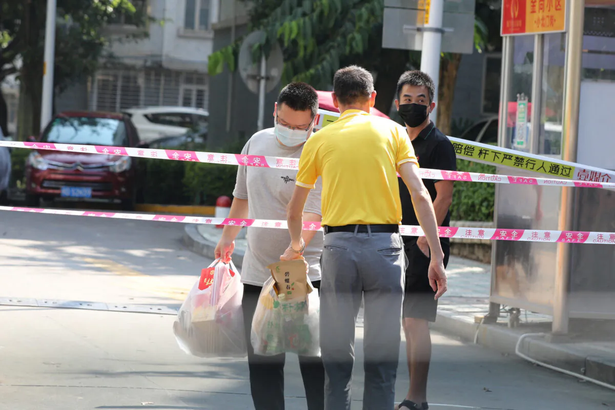 Residents transfer daily necessities at a residential area under tight restrictions due to cases of the COVID-19 virus in Xiamen in China's eastern Fujian province on Sept. 14, 2021. (STR/AFP via Getty Images)