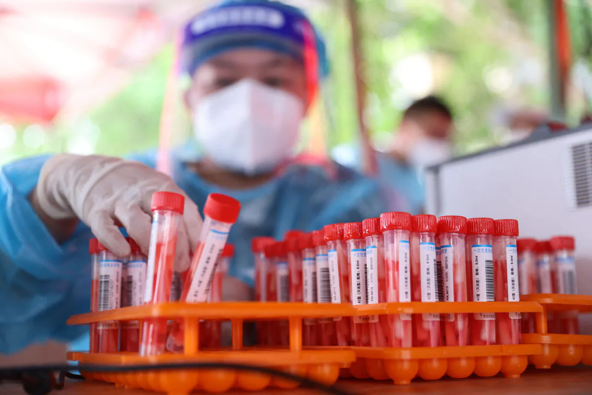 A medical worker collects samples to be tested for the Covid-19 coronavirus in Xiamen, Fujian Province, China, on Sept. 18, 2021. (STR/AFP via Getty Images)