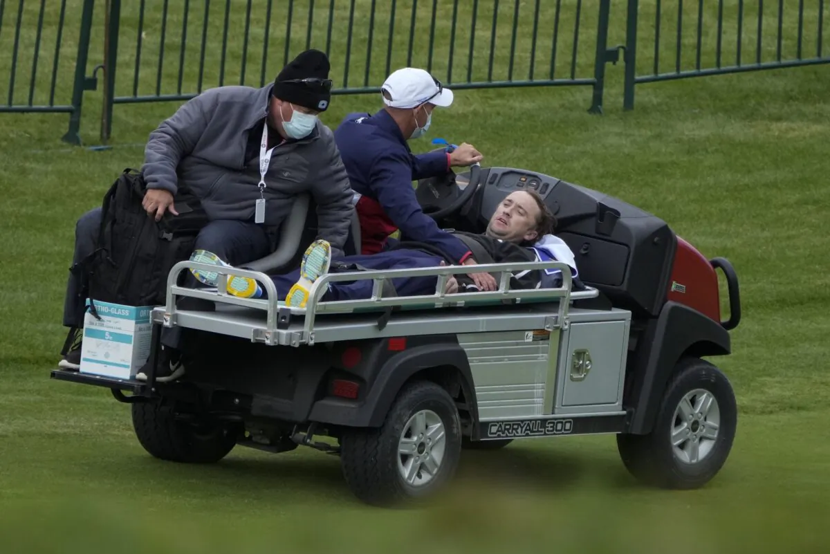 Actor Tom Felton is helped after collapsing on the 18th hole during a practice day at the Ryder Cup at the Whistling Straits Golf Course in Sheboygan, Wis., on Sept. 23, 2021. (Ashley Landis/AP Photo)