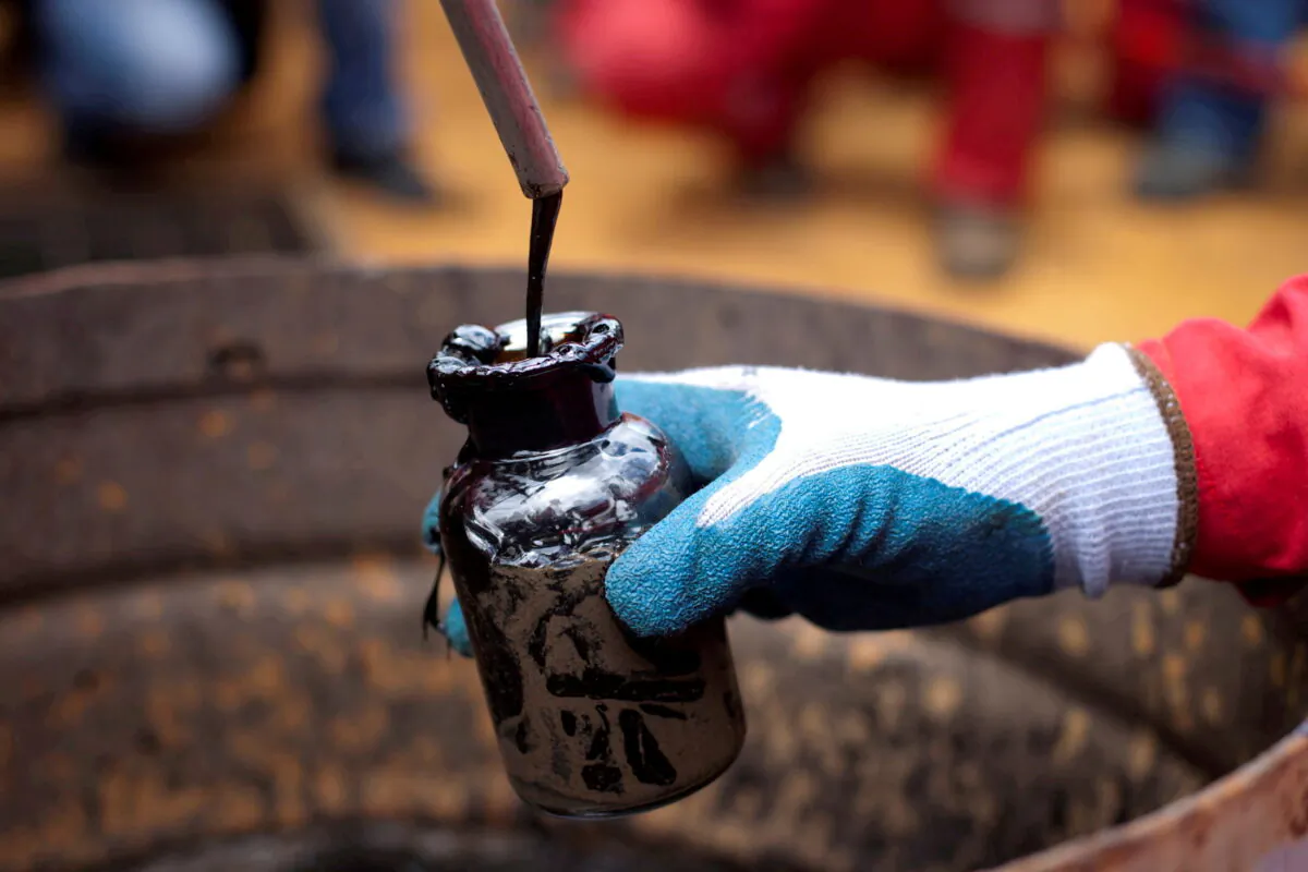 A worker collects a crude oil sample at an oil well operated by Venezuela's state oil company PDVSA in Morichal, Venezuela on July 28, 2011. (Carlos Garcia Rawlins/Reuters)