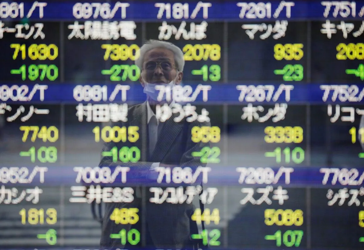 A man wearing a protective mask, amid the COVID-19 outbreak, is reflected on an electronic board displaying stock prices outside a brokerage in Tokyo, Japan on Sept. 21, 2021. (Kim Kyung-Hoon/Reuters)