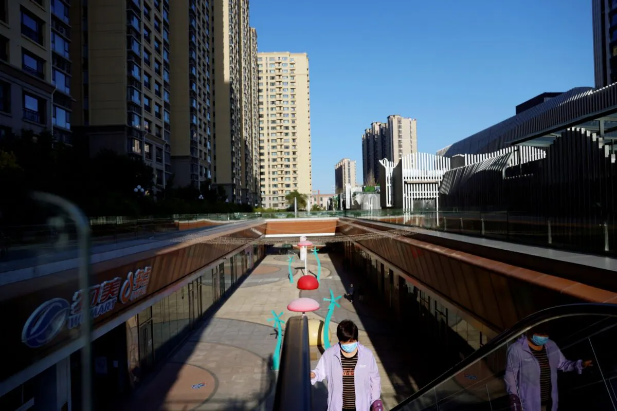 A woman rides an escalator at an Evergrande Plaza shopping mall in a residential compound developed by China Evergrande Group in Beijing, China on Sept. 22, 2021. (Carlos Garcia Rawlins/Reuters)