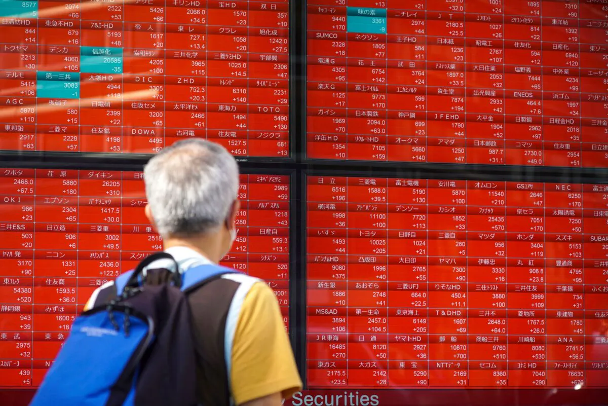 A pedestrian looks at an electronic quotation board displaying companies' stock prices at the Tokyo Stock Exchange in Tokyo, Japan on Sept. 24, 2021. (Kazuhiro Nogi/AFP via Getty Images)