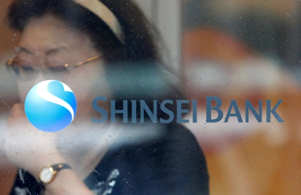 A woman walks past a logo of the Shinsei Bank at its branch in Yokohama, south of Tokyo, Japan on June 23, 2010. (Issei Kato/Reuters)