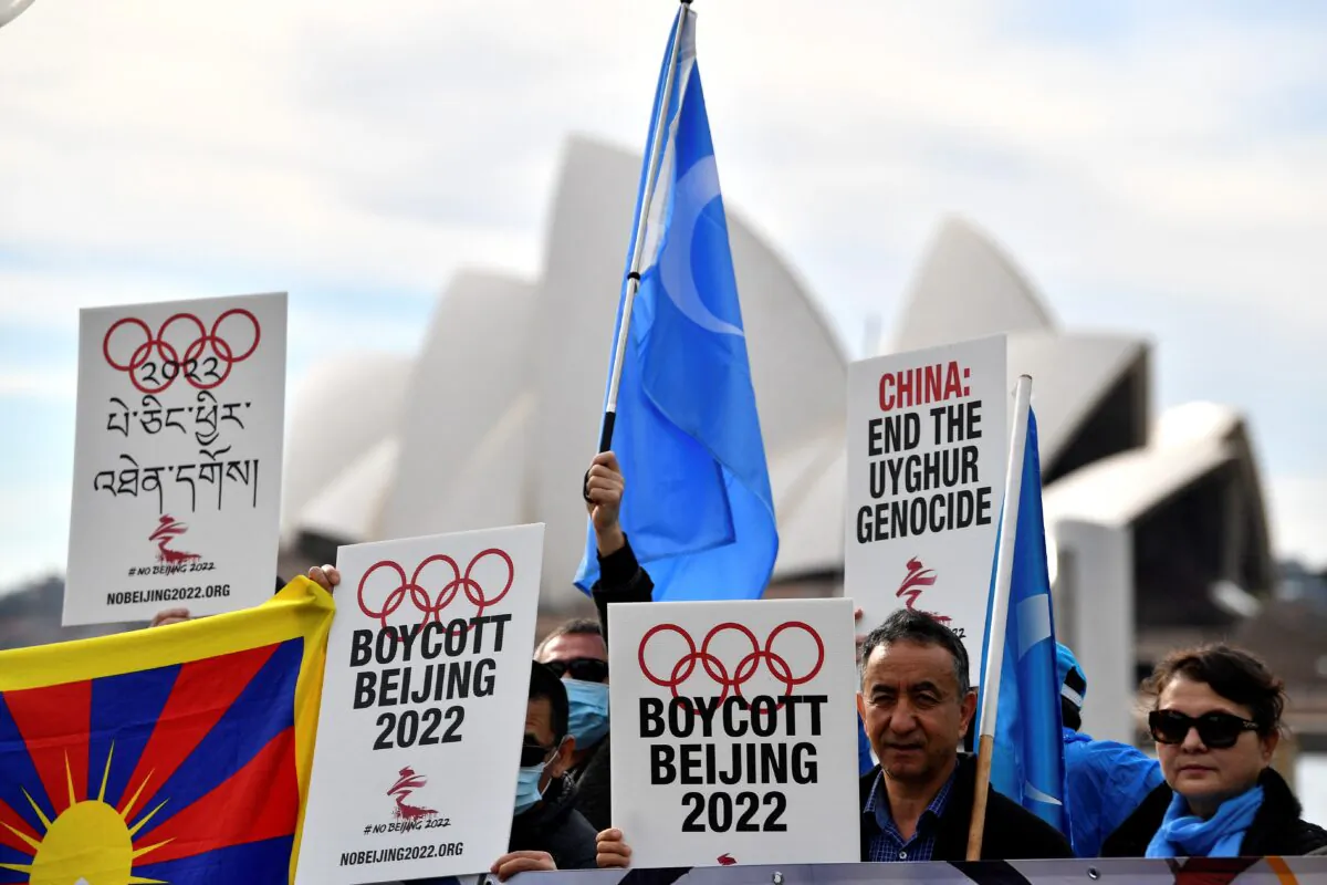 Protesters hold up placards and banners as they attend a demonstration to call on the Australian government to boycott the 2022 Beijing Winter Olympics over China's human rights record, in Sidney, Australia, on June 23, 2021. (Saeed Khan/AFP via Getty Images)