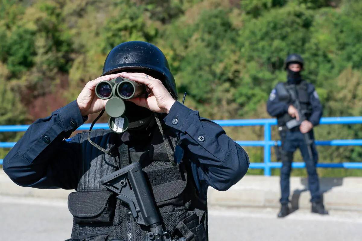 Kosovo police officers patrol the bridge over Gazivode Lake near the northern Kosovo border crossing of Brnjak on the fifth day of protest on Sept. 24, 2021. Ethnic Serbs in Kosovo have been blocking the border for a fifth straight day to protest a decision by Kosovo authorities to start removing Serbian license plates from cars entering the country, raising fears such incidents could unleash much deeper tensions between the two Balkan foes. (Visar Kryeziu /AP Photo)
